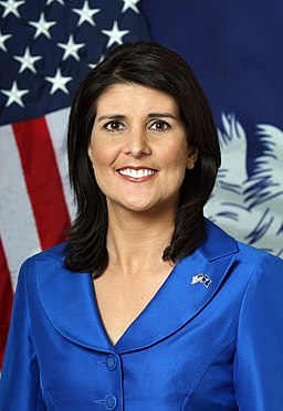 Nikki Haley official photo with flag in background.