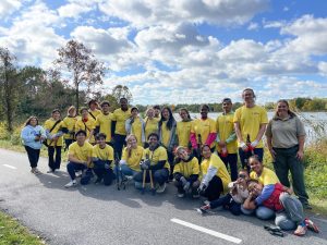 A group of students in yellow shirts posing together at a park.