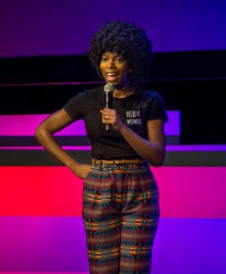 Comedian performing on a stage.