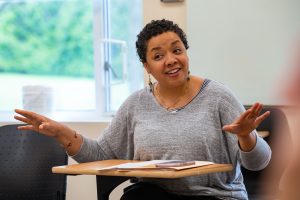A professor speaking with students in a class.