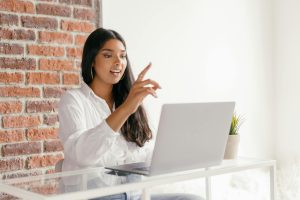 A Woman Engaged in a Video Call Using a Laptop