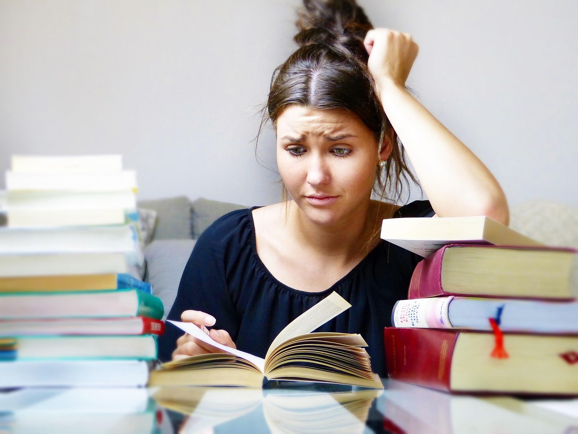 A woman is reading a book with a frustrating face.